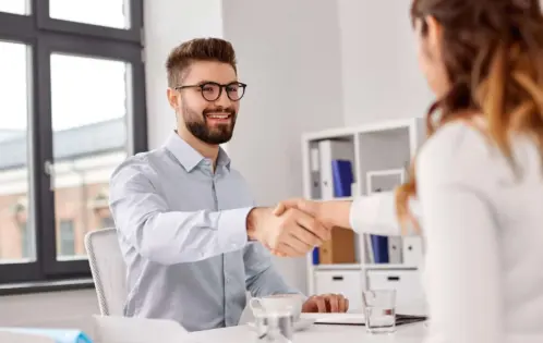 Man and woman shaking hands at a job interview