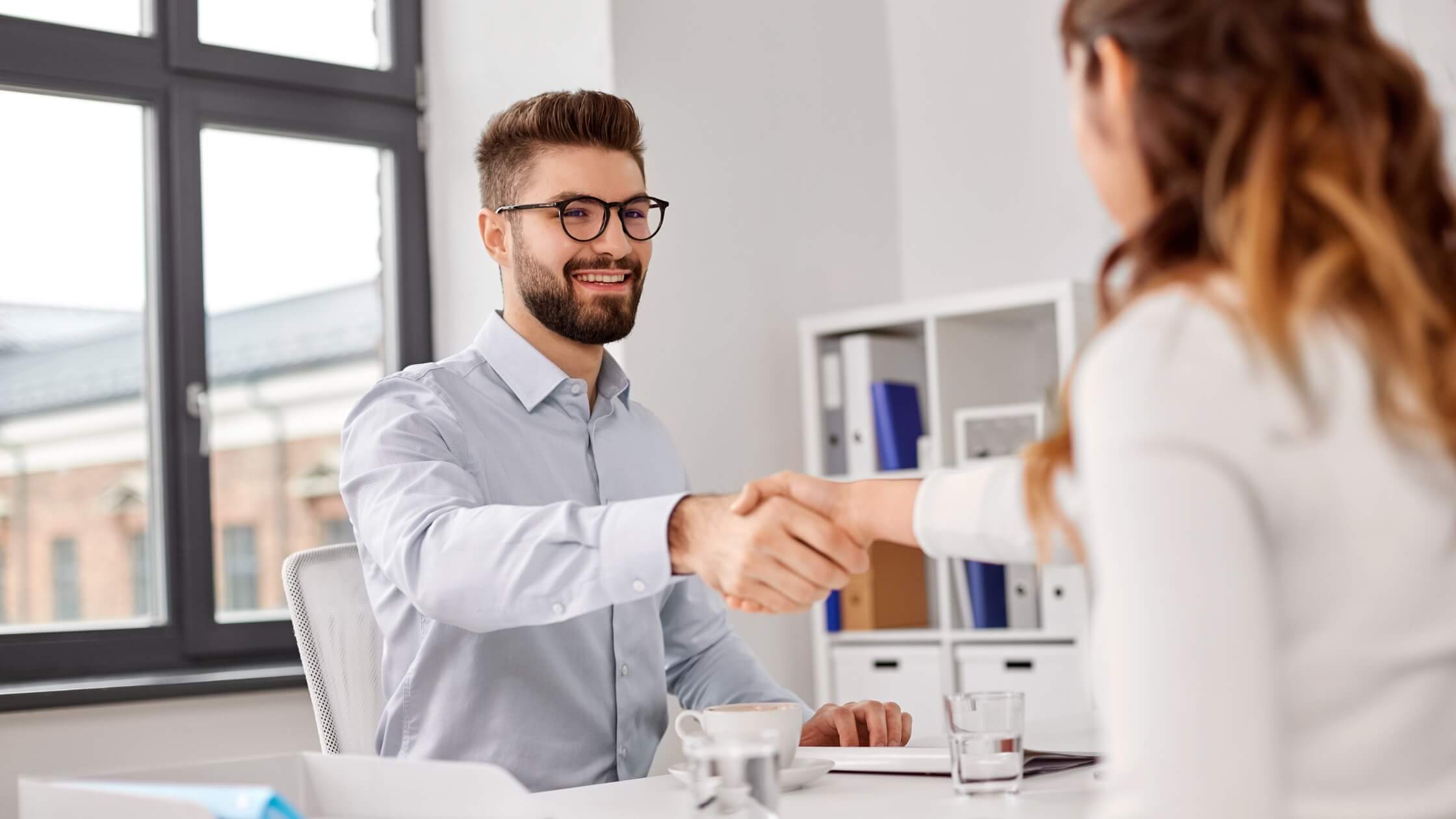 Man and woman shaking hands at a job interview