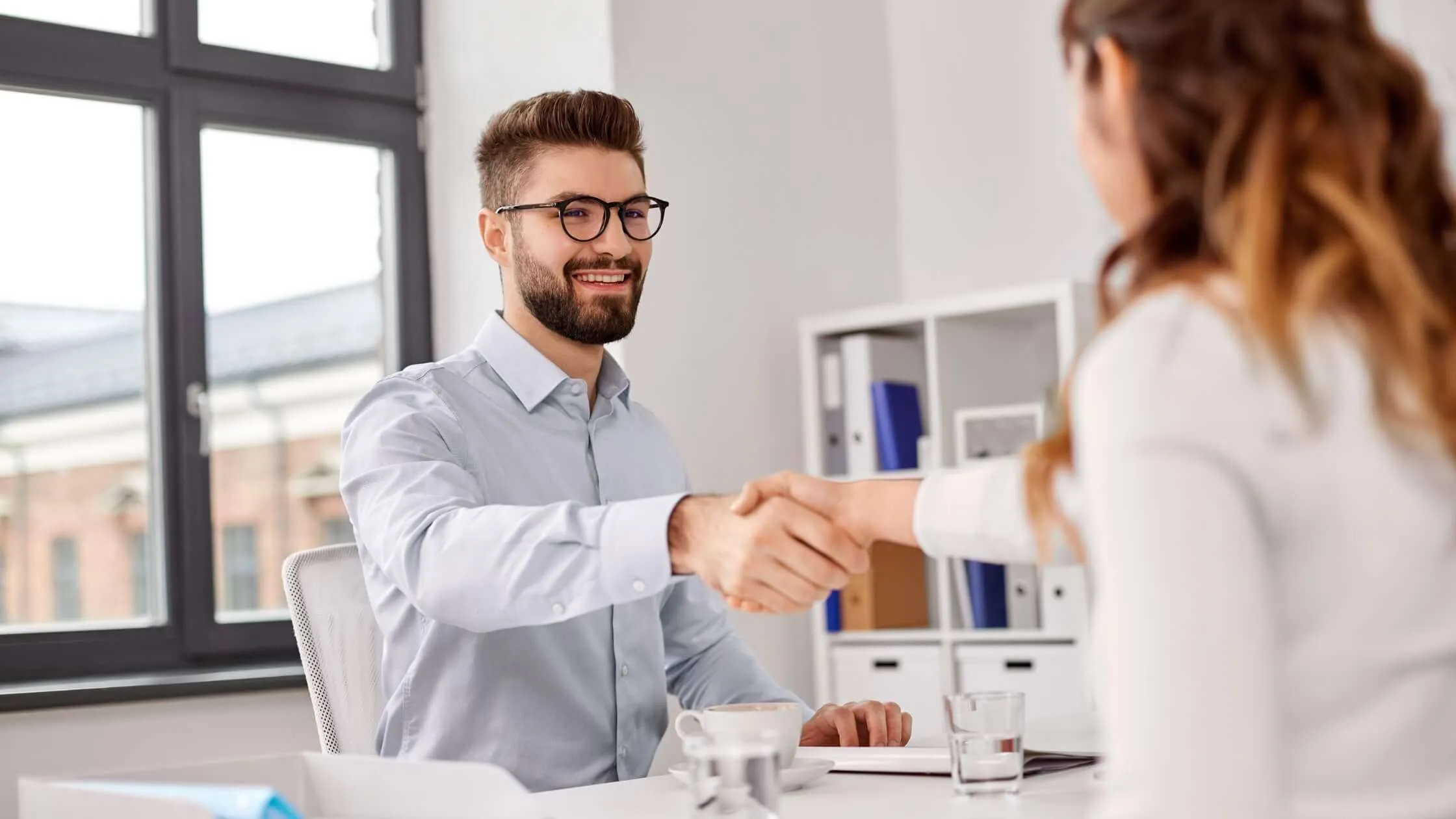 Man and woman shaking hands at a job interview
